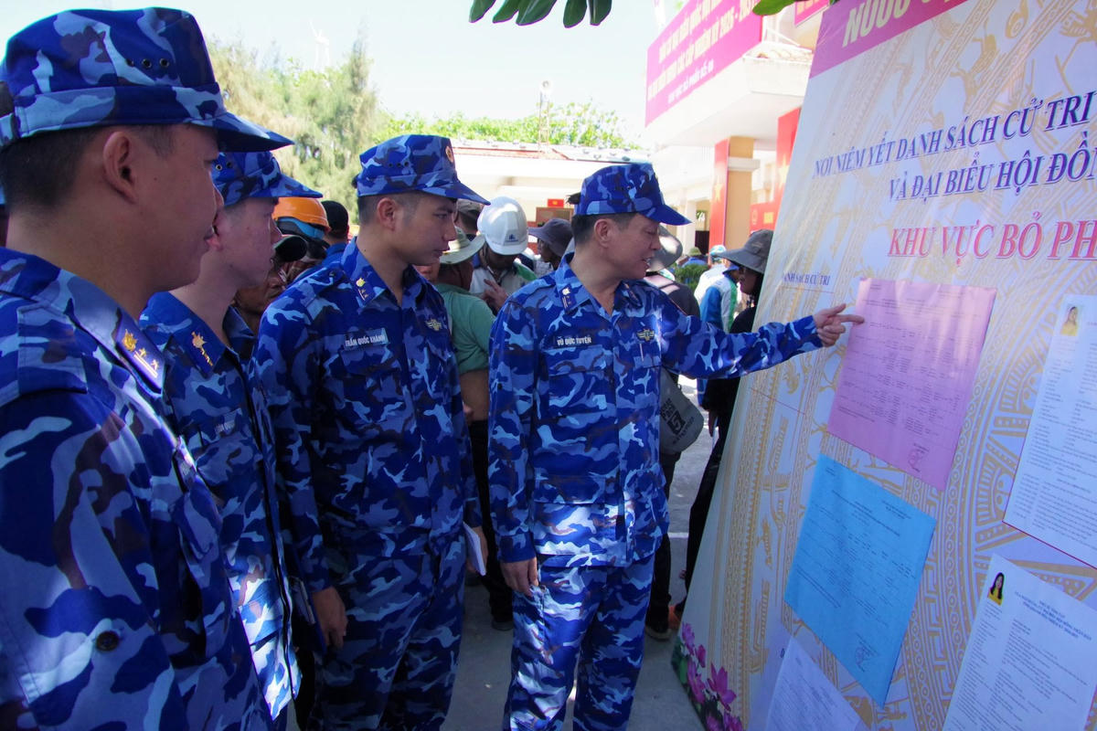 Cán bộ, chiến sĩ tàu CSB 8002 tại khu vực niêm yết danh sách ĐBQH khóa XVI và Đại biểu HĐND các cấp nhiệm kỳ 2026-2031 trên Đặc khu Trường Sa. Ảnh: CBS 2.