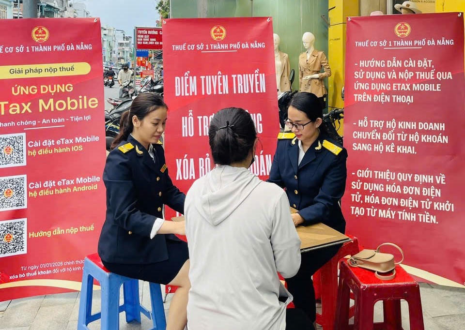 Cán bộ thuế hướng dẫn hộ kinh doanh đường Lý Thái Tổ, phường Thanh Khê, TP Đà Nẵng. Ảnh: Nguyễn Tú.