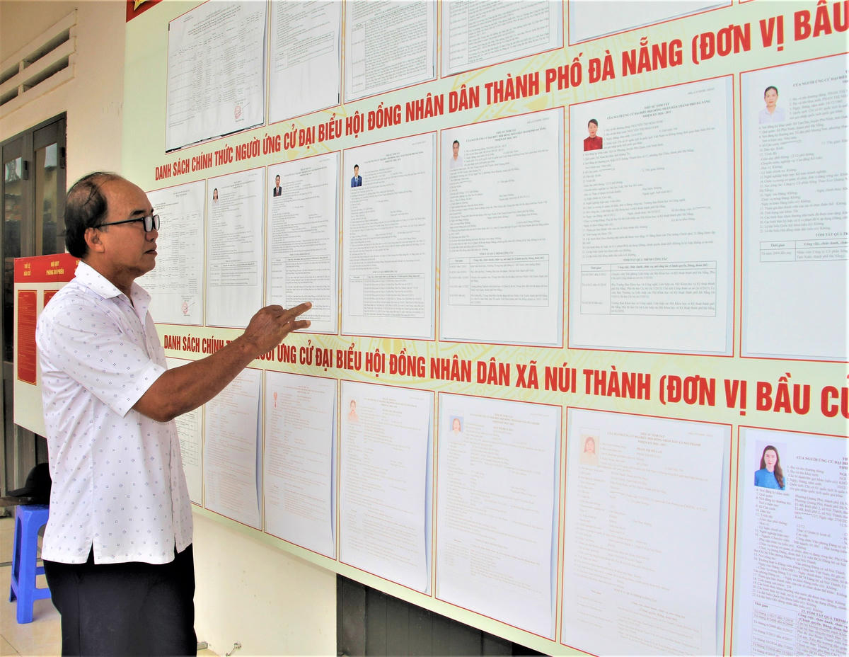 Ông Nguyễn Đình Sang kiểm tra lại danh sách niêm yết ứng cử viên ĐBQH và Đại biểu HĐND các cấp. Ảnh: Chí Đại.