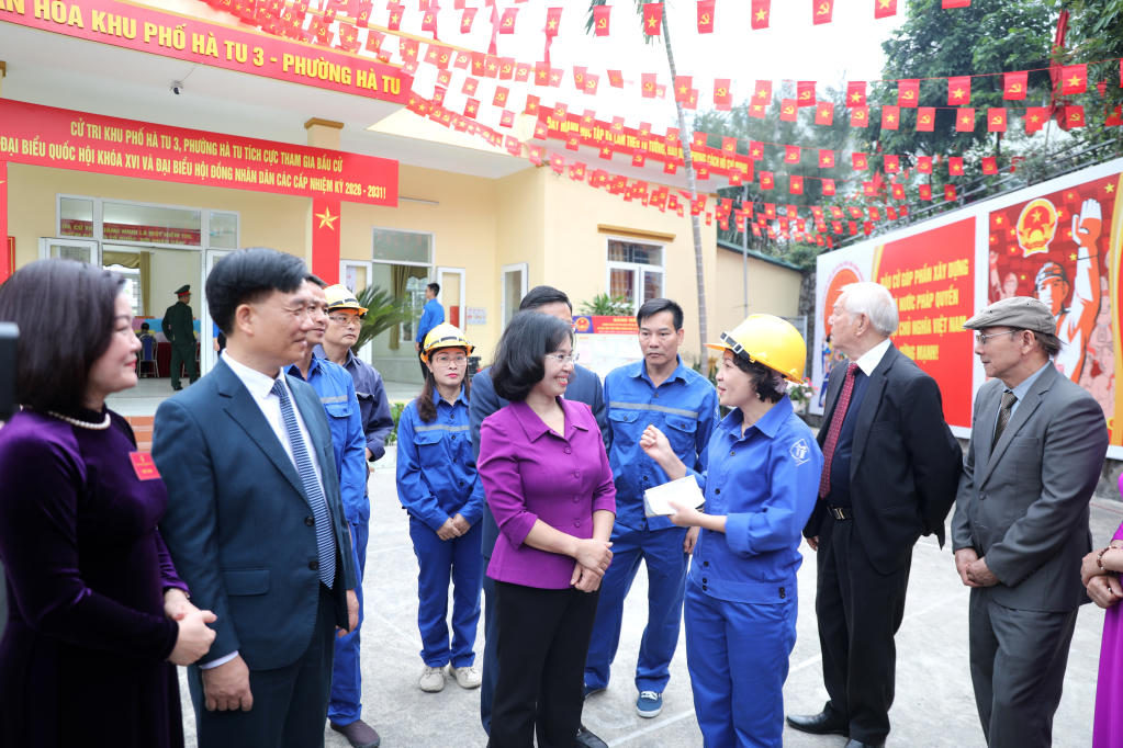 Phó Bí thư Thường trực Tỉnh ủy, Chủ tịch HĐND tỉnh Quảng Ninh Trịnh Thị Minh Thanh trao đổi với cử tri là công nhân ngành Than bầu cử tại Khu vực bỏ phiếu số 18 phường Hà Tu.