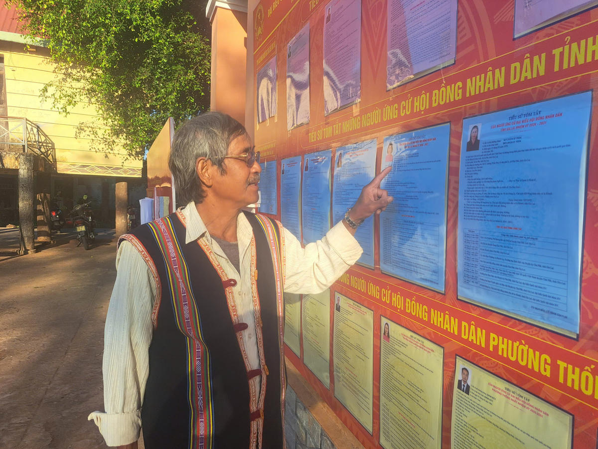 Già làng Ksor Ko đang xem niêm yết danh sách ứng cử viên. Ảnh: CV.