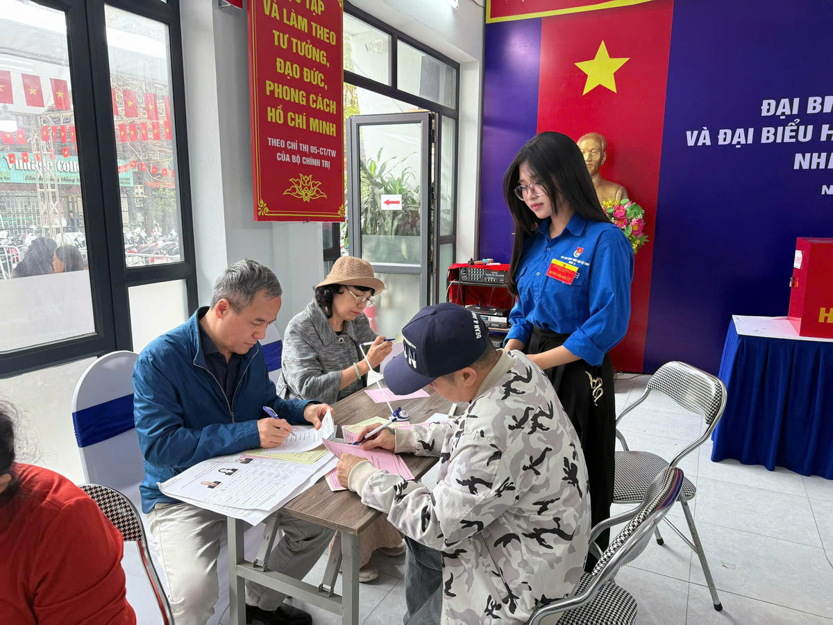 Sinh viên tình nguyện tận tình hướng dẫn cử tri, đặc biệt là người cao tuổi, thực hiện các bước trong quy trình bỏ phiếu.