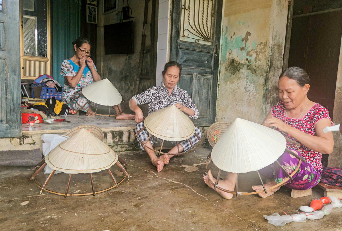 Nhiều hộ gia đình trong thôn đều sắp xếp công việc để đi bỏ phiếu sớm rồi trở về tiếp tục chằm nón. Ảnh: Cẩm Kỳ 