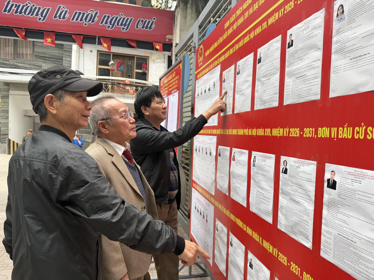 Cử tri tìm hiểu thông tin các đại biểu trước khi thực hiện quyền bỏ phiếu tại khu vực bỏ phiếu số 10, phường Ba Đình.