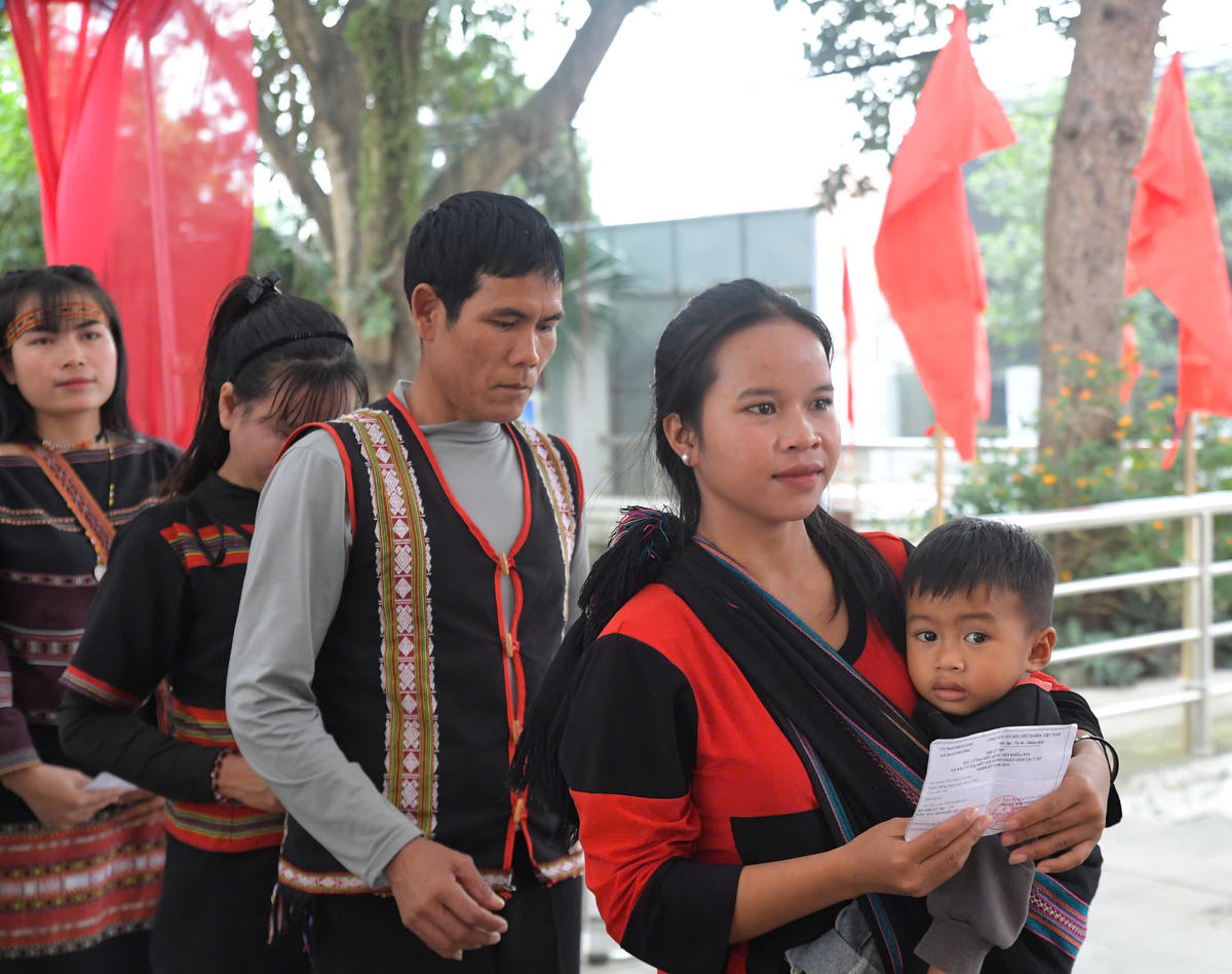 Em bé cùng mẹ đi bầu cử. 