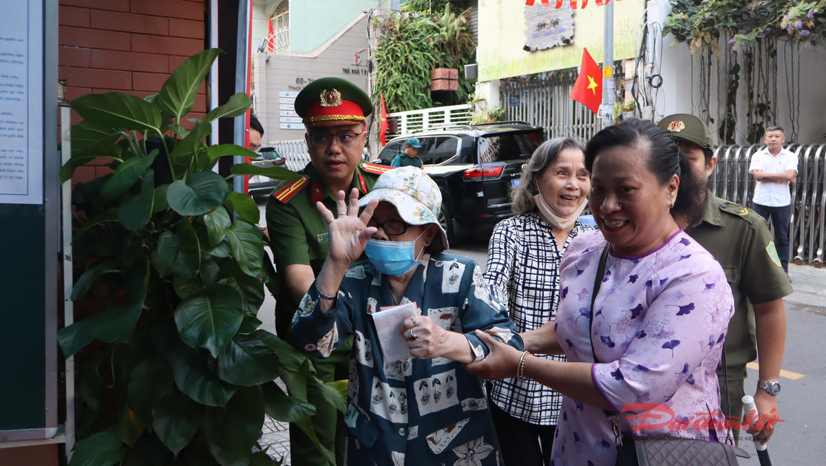 Lực lượng công an và dân quân hỗ trợ cử tri cao tuổi đến điểm bỏ phiếu 96 Thạch Thị Thanh, phường Tân Định. Ảnh: Hồng Phúc.