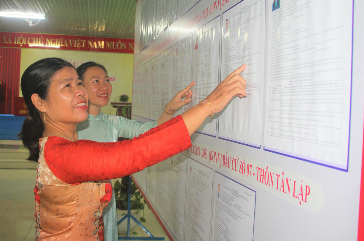 Cư tri thôn Tân Lập xem niêm yết danh sách ứng cử viên. Ảnh: Tấn Thành.