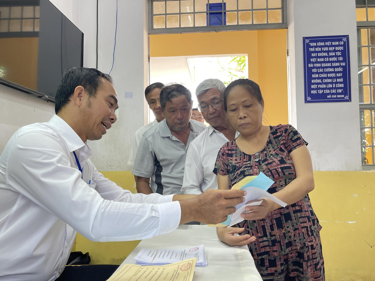 Người dân nô nức nhận phiếu bầu và hướng dẫn từ lực lượng chức năng. Ảnh: Đ.Xá.