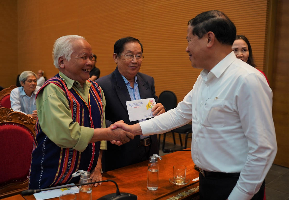 Chủ tịch UBND tỉnh Gia Lai Phạm Anh Tuấn (bên phải) bắt tay và trò chuyện với đại biểu văn nghệ sĩ, trí thức, kiều bào. Ảnh: Đình Sang.