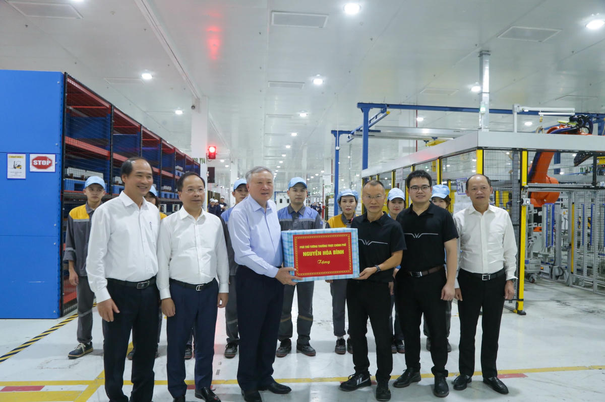 Phó Thủ tướng Thường trực Chính phủ Nguyễn Hòa Bình và lãnh đạo tỉnh Hà Tĩnh tặng quà cho cán bộ và người lao động tại Nhà máy Sản xuất Pin VinES. Ảnh: PVA.