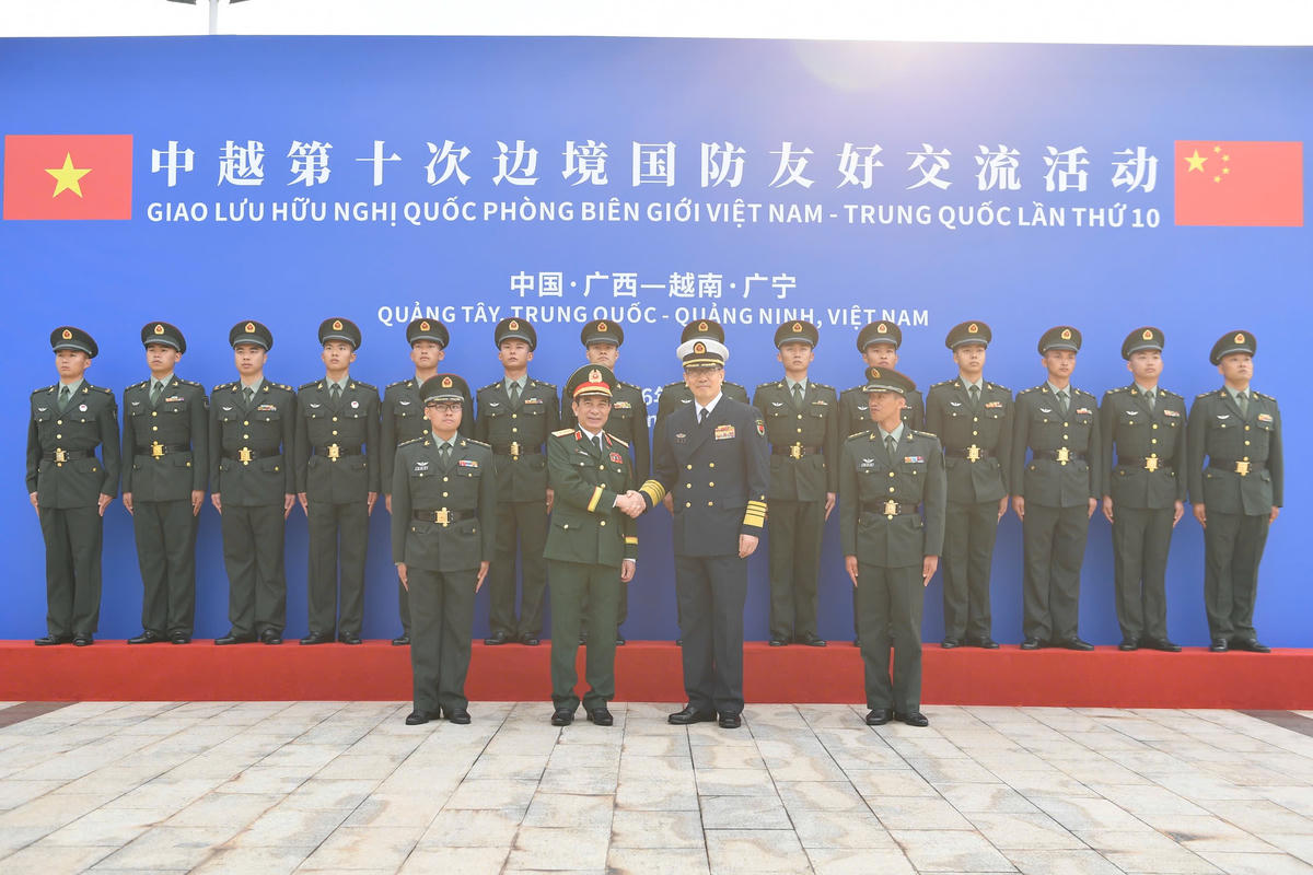 Bộ trưởng Bộ Quốc phòng hai nước chụp ảnh lưu niệm cùng các cán bộ, chiến sĩ Đại đội Biên phòng Đông Hưng. . 