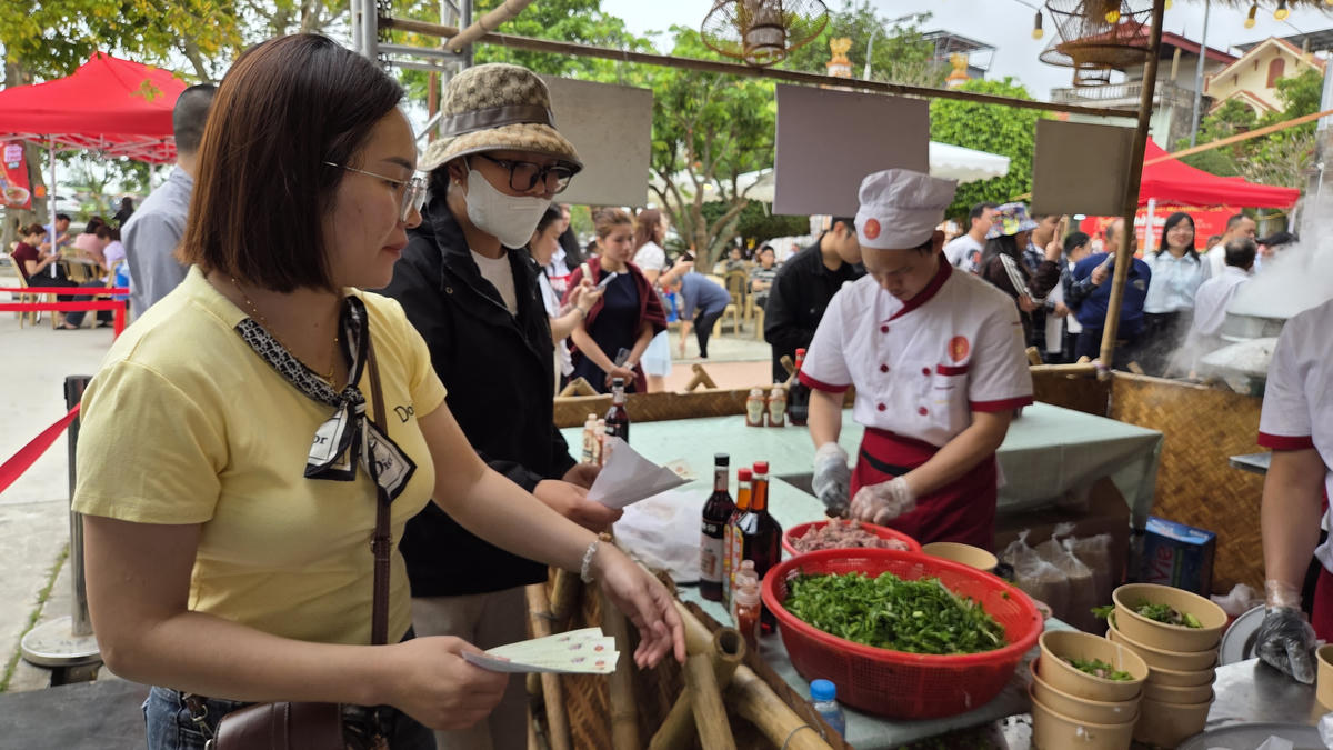 Khách tham quan được phát phiếu trải nghiệm phở Vân Cù ngay tại đình làng. Ảnh: Duy Hưng.