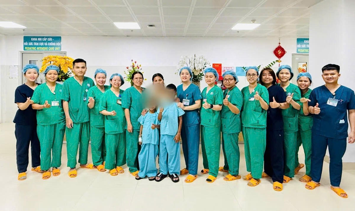 2 em bệnh nhi đã hồi phục sức khỏe chụp ảnh lưu niệm cùng các y, bác sĩ của bệnh viện. Ảnh: CV.