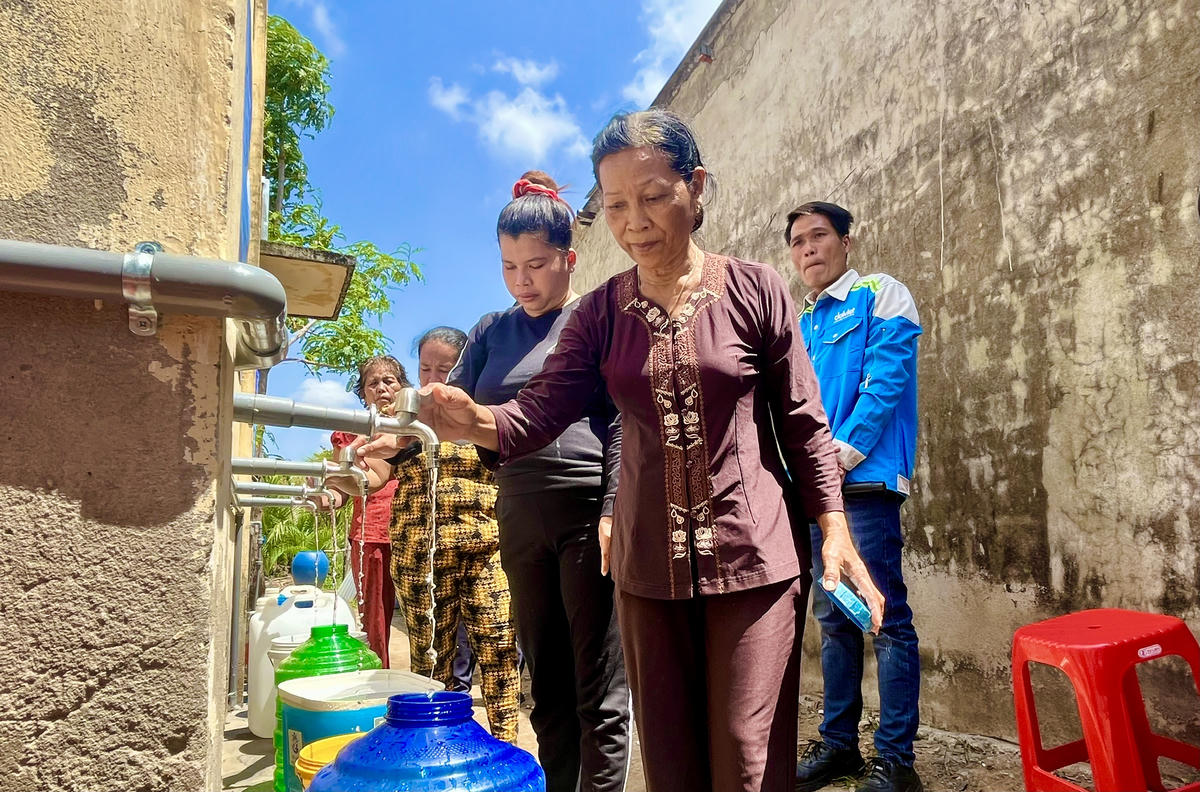 Người dân phường Khánh Hoà lấy nước đã qua xử lý từ hệ thống máy lọc nước vừa được trao tặng. Ảnh: Thanh Tiến