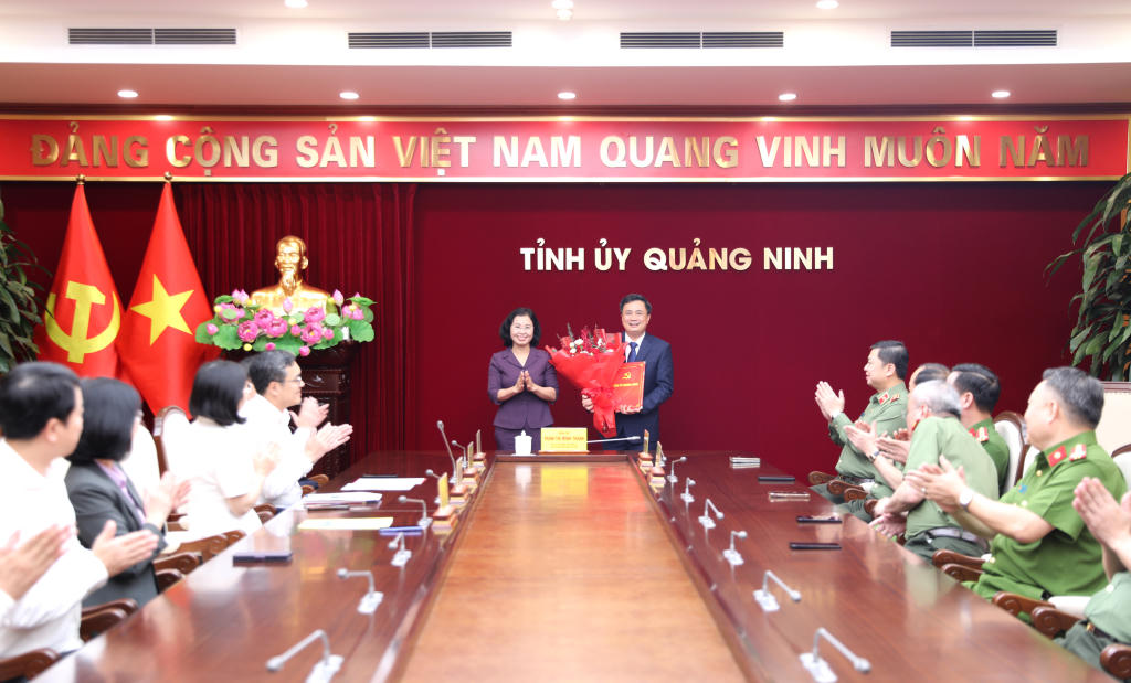 Phó Bí thư Thường trực Tỉnh ủy, Chủ tịch HĐND tỉnh Quảng Ninh Trịnh Thị Minh Thanh trao quyết định, tặng hoa chúc mừng Thượng tá Nguyễn Duy Dũng, Phó Trưởng Ban Nội chính Tỉnh ủy Quảng Ninh. Ảnh: QMG
