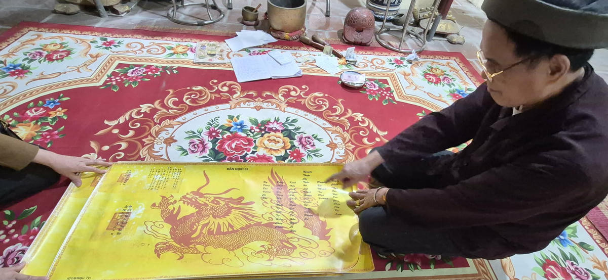 Ông Trần Văn Nam - người trông coi, gắn bó lâu năm với miếu làng Tĩnh Luyện cùng bản Sắc phong. Ảnh: Xuân Trường.