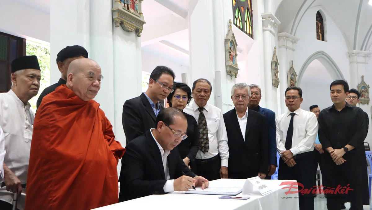 Ông Hoàng Công Thủy thay mặt đoàn ghi vào sổ tang Đức Hồng y Gioan Baotixita Phạm Minh Mẫn. Ảnh: Thành Luân.