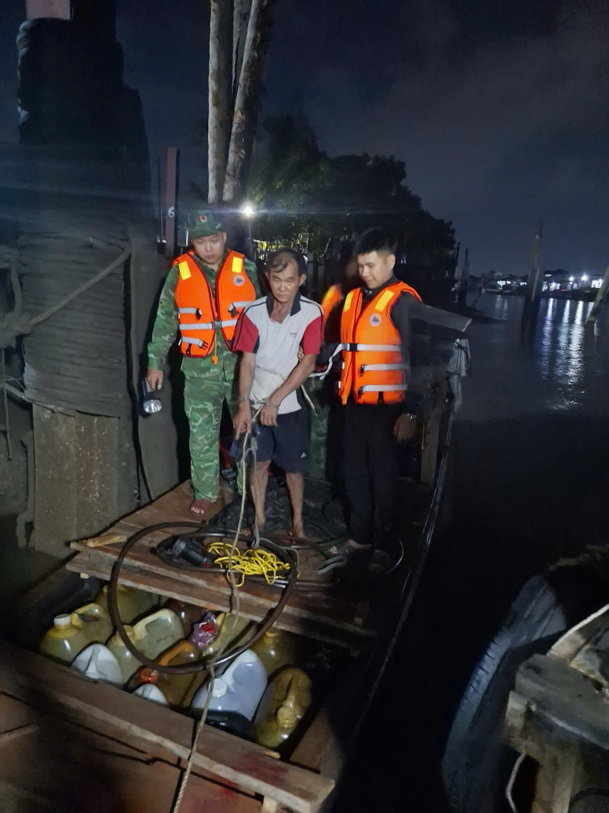 Ông N.V.H. (53 tuổi, ngụ xã Thạnh Trị, tỉnh Vĩnh Long) bị lực lượng chức năng bắt quả tang điều khiển ghe tam bản chở dầu không rõ nguồn gốc. Ảnh: Trần Giỏi.