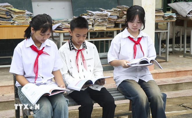 Học sinh Trường Phổ thông Dân tộc bán trú THCS Chiềng Sơ (xã Mường Luân) đọc sách giáo khoa mới. (Ảnh: TTXVN phát).