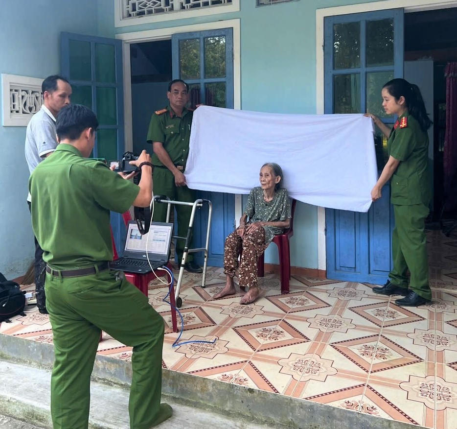 Lực lượng Công an xã Trà My giúp người già yếu làm căn cước. Ảnh: CV.