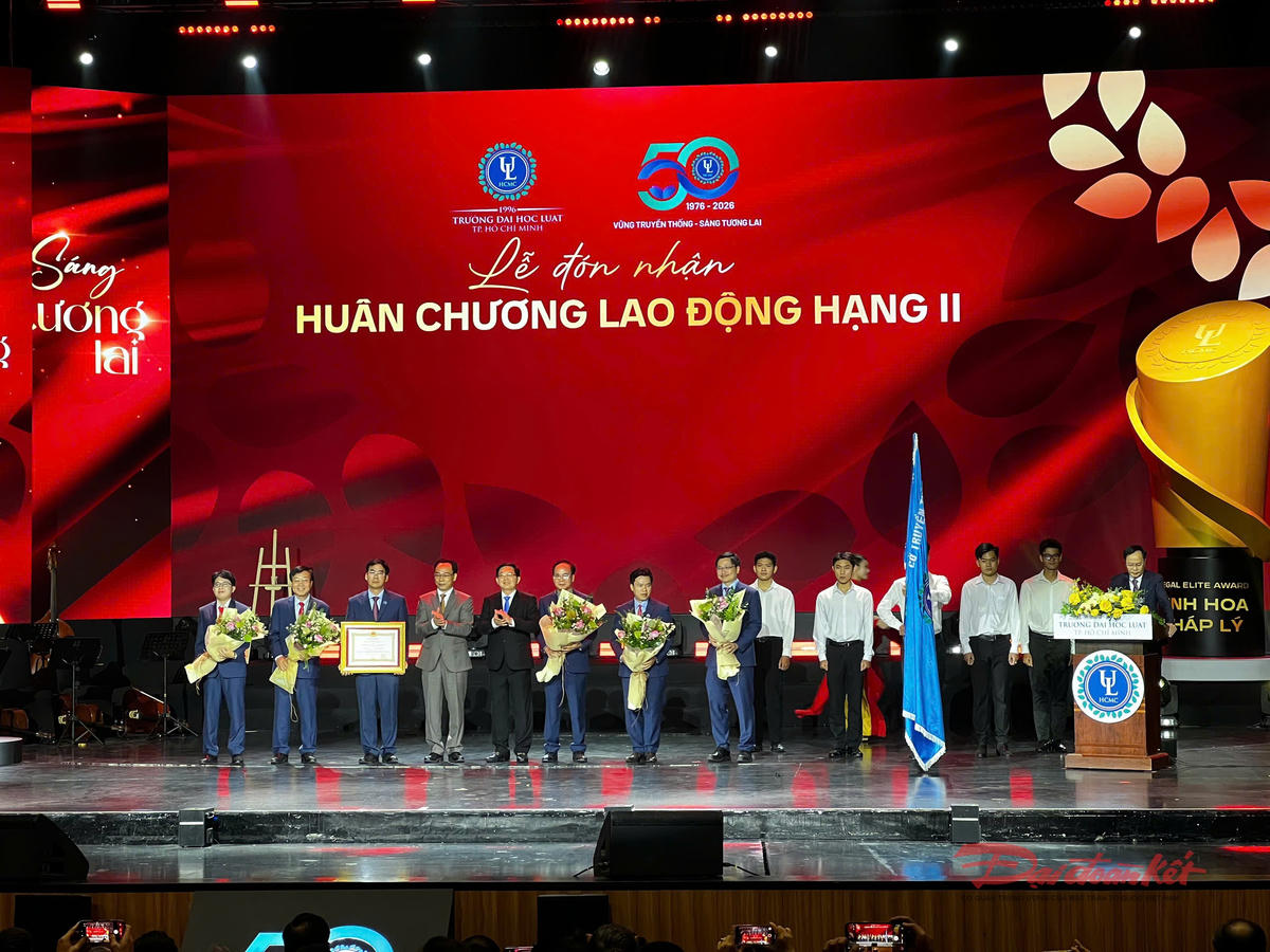 Phó Thủ tướng Hồ Quốc Dũng và Quyền Bộ trưởng Bộ GDĐT Hoàng Minh Sơn trao tặng Huân chương Lao động hạng Nhì và hoa cho tập thể lãnh đạo Trường Đại học Luật TP Hồ Chí Minh. Ảnh: H.Phúc.