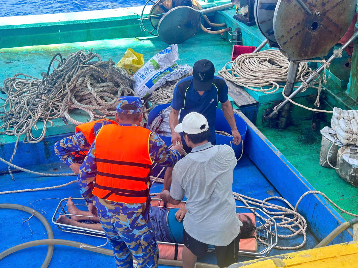 Quân y nhà giàn DK1/11 đưa ngư dân từ tàu cá sang nhà giàn. Ảnh: Quách Nghĩa.