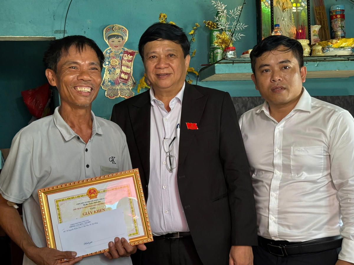 Trưởng Phòng Văn hóa Xã hội phường Hải Vân Nguyễn Bá Nam; Chủ tịch UBND phường Nguyễn Thúc Dũng trao giấy khen cho ông Lê Công Quang. Ảnh: Nguyễn Tú.