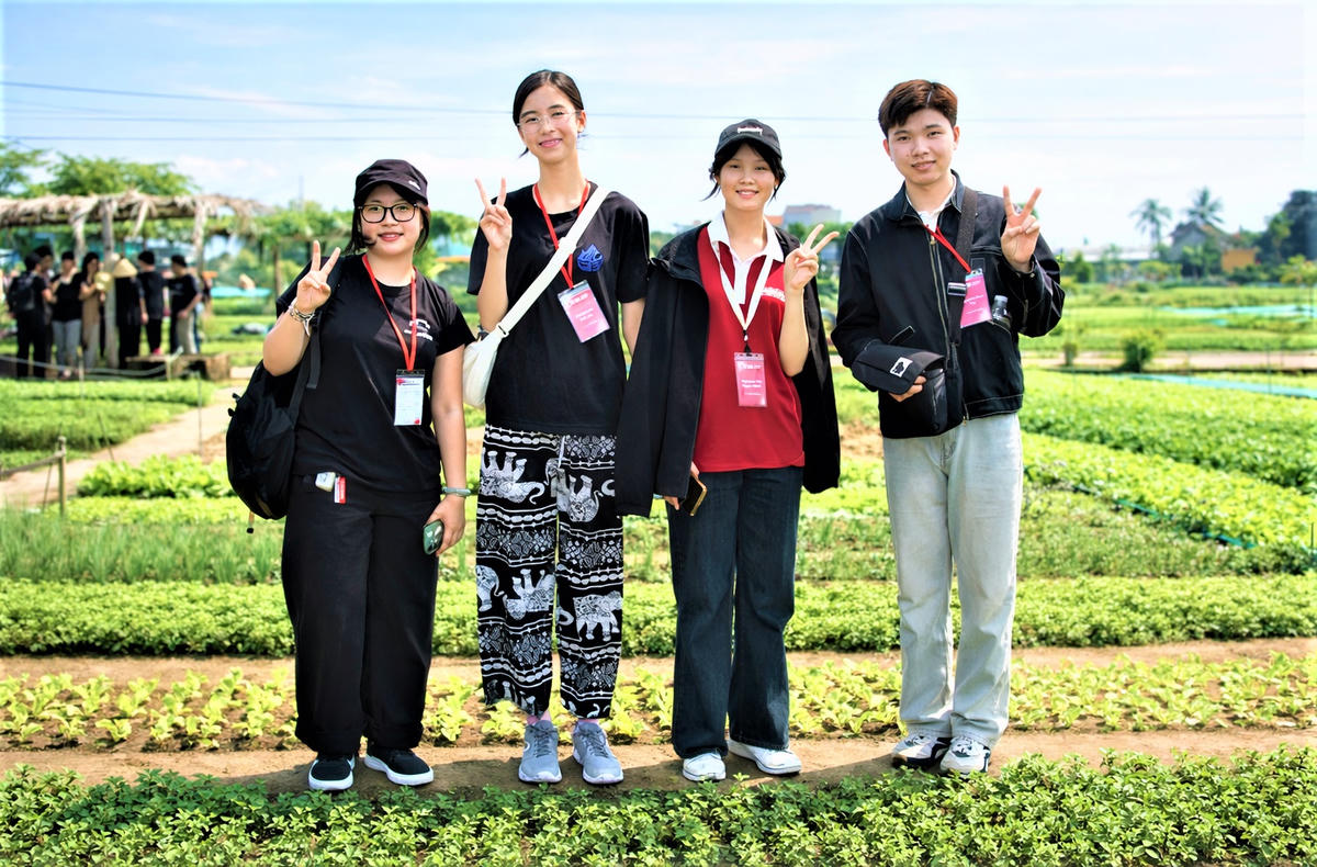 Du khách Chloe (bên trái, không đội mũ) check in tại làng rau Trà Quế. Ảnh: Chí Đại.