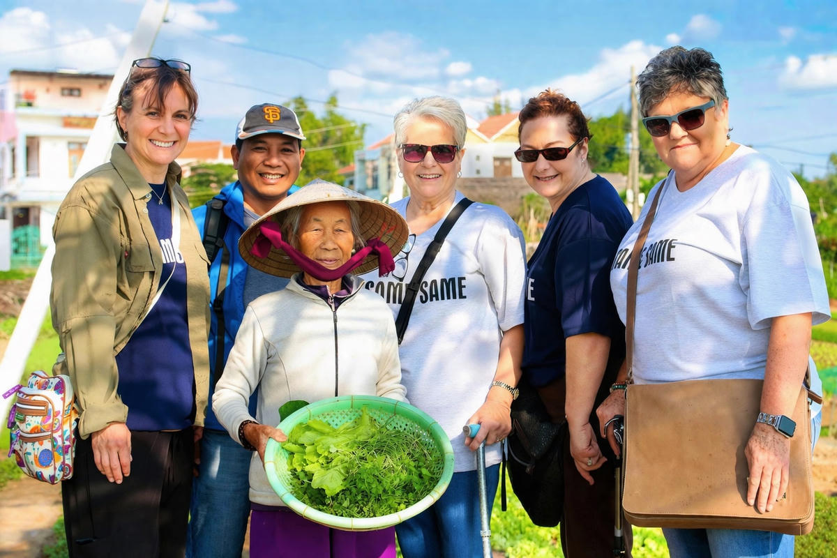 Du khách chụp ảnh lưu niệm cùng người dân ở làng rau Trà Quế. Ảnh: Chí Đại.