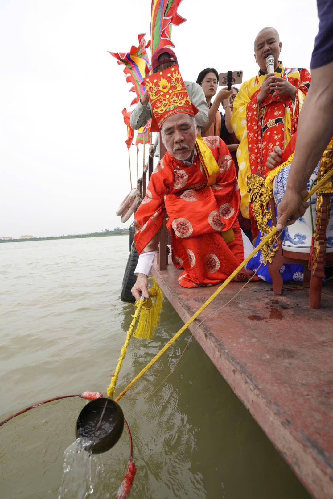 Chủ lễ dùng gáo đồng múc 18 gáo nước sạch, qua màng lọc đổ vào chóe cúng được phủ nhiễu đỏ. 