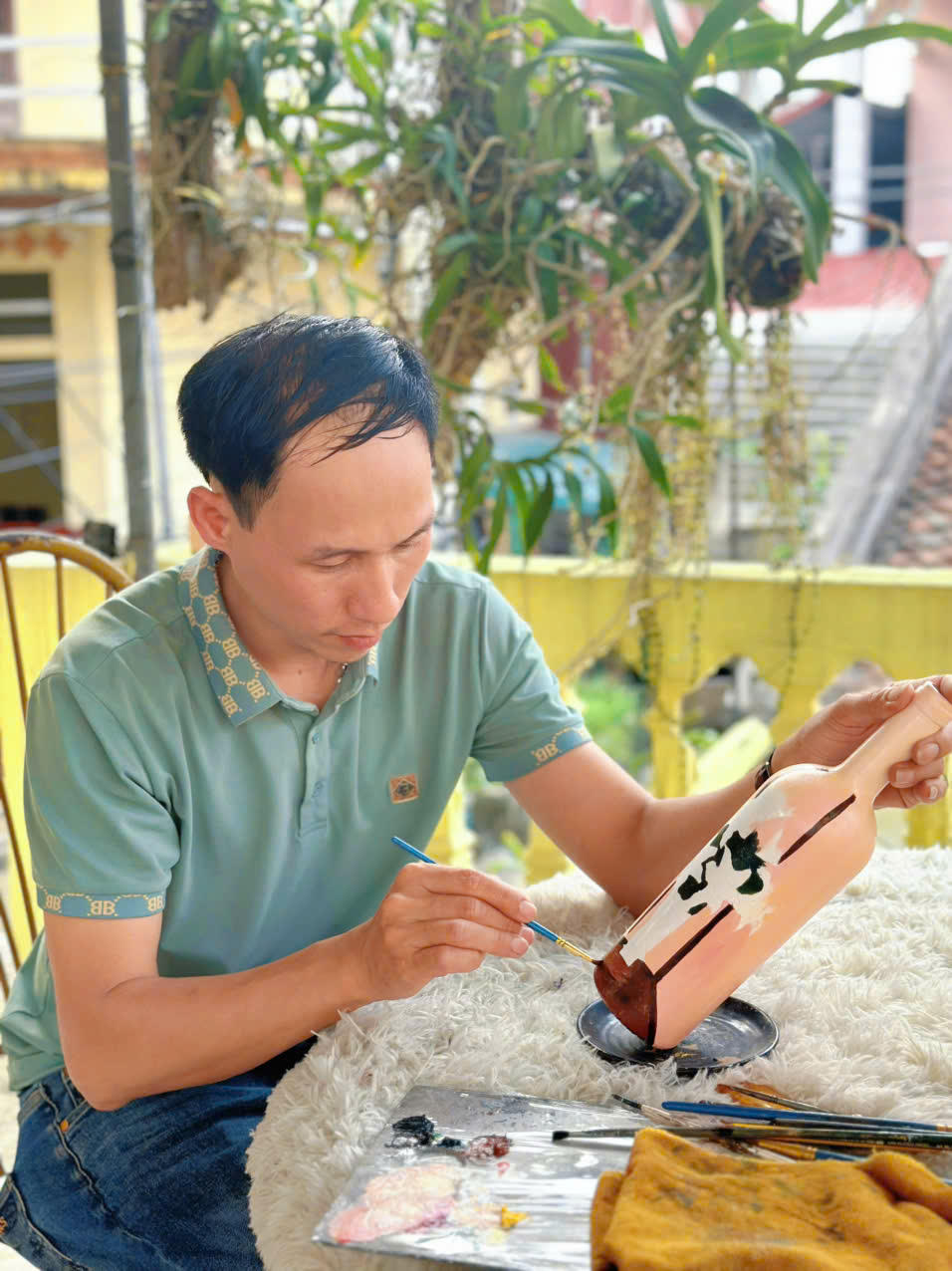 Thầy Khôi đang thực hiện bức tranh hoa loa kèn.