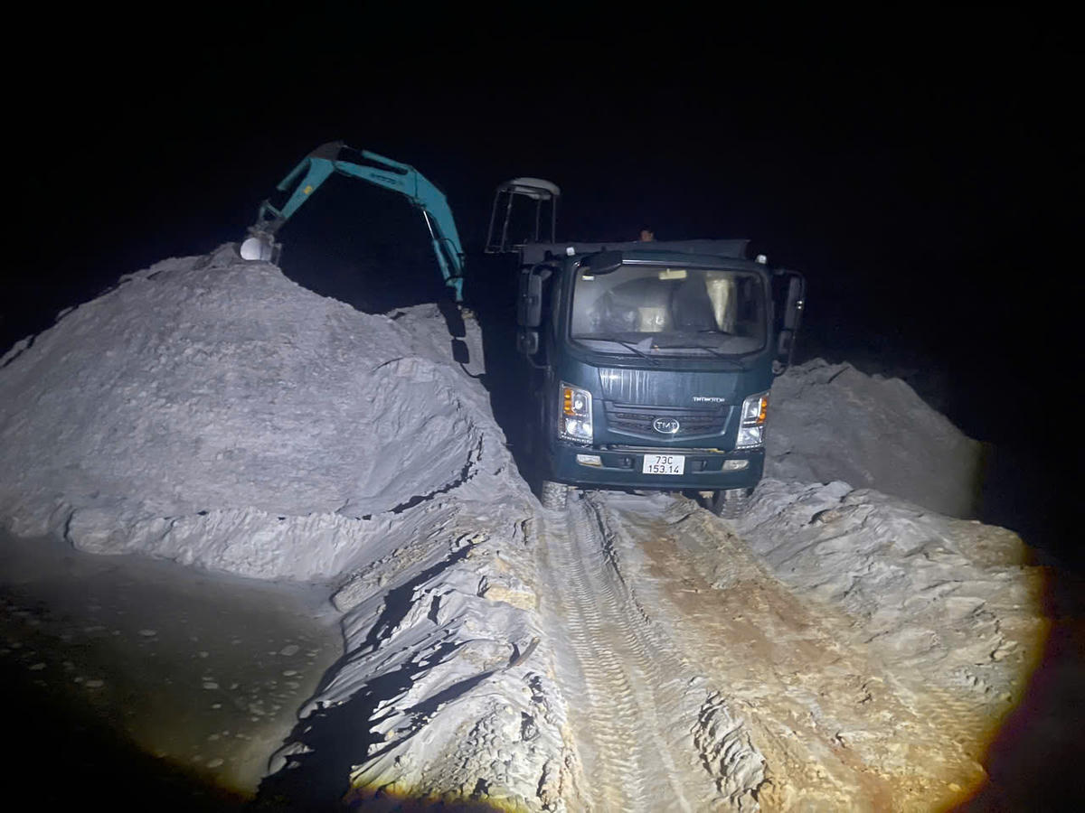 Máy xúc đào bánh xích đang múc cát lên xe ô tô tải thì bị cơ quan công an bắt quả tang. Ảnh: CAQT