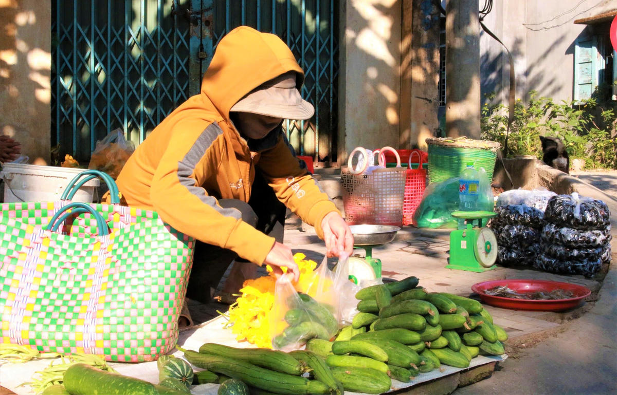 Bà Y Ngưng ngồi bán rau, củ quả. Ảnh: C.Đ.