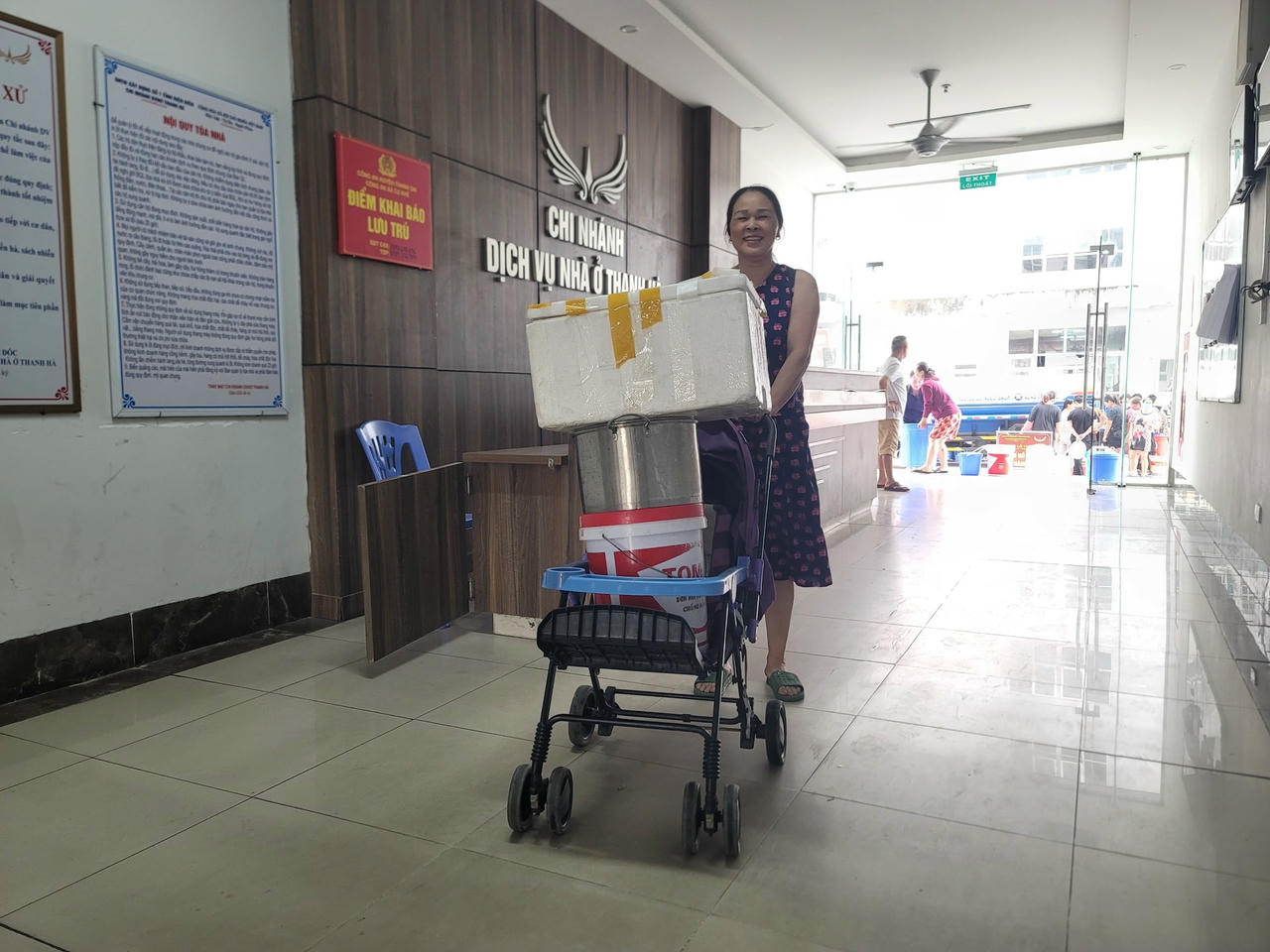 Bà Nguyễn Thị Thêm dùng xe nôi của cháu ngoại đi chở nước. Theo bà, 2 con đi làm, cháu đi học, bố mẹ cháu đi làm trực nước, mất 6 ngày rồi, 