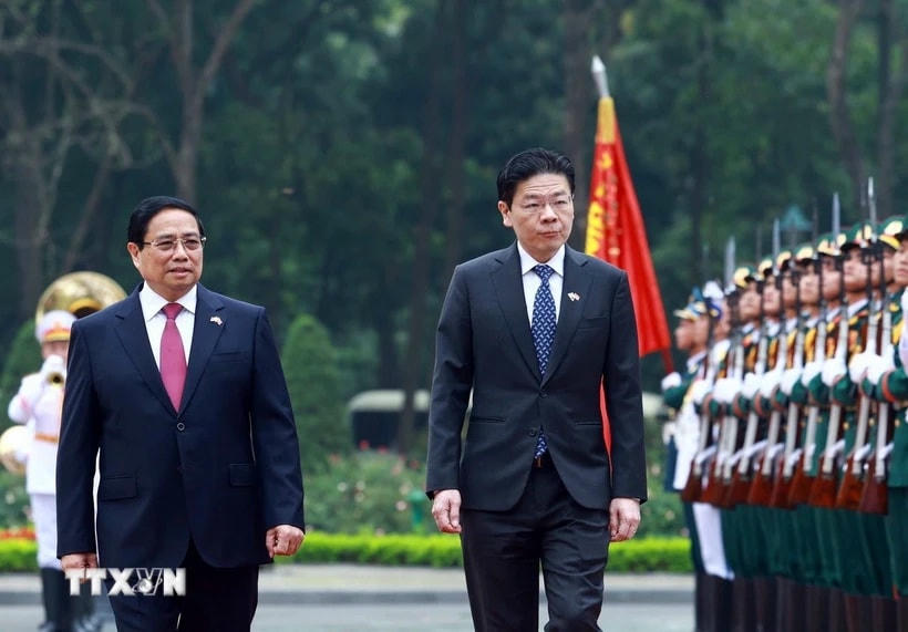 Thủ tướng Phạm Minh Chính và Thủ tướng Singapore Lawrence Wong duyệt Đội danh dự Quân đội nhân dân Việt Nam. (Ảnh: Dương Giang/TTXVN)