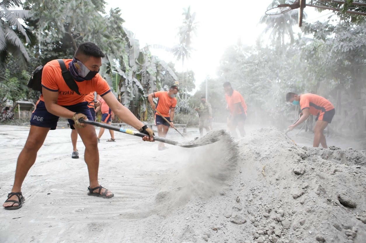 Nhân viên cảnh sát biển xúc tro để dọn đường. Ảnh: Getty Images.