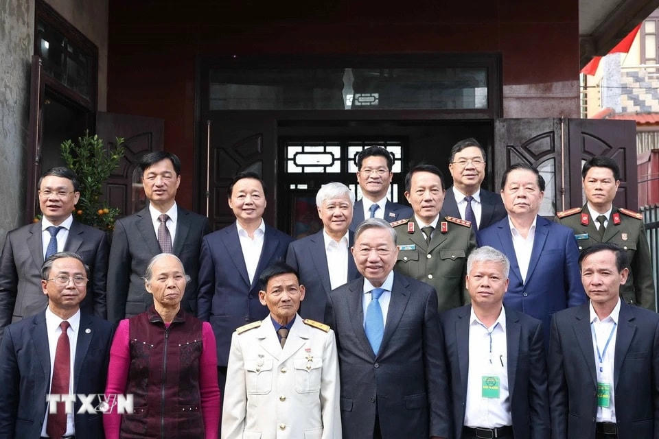 Tổng Bí thư Tô Lâm và các đại biểu với gia đình Anh hùng Lực lượng Vũ trang nhân dân Đinh Quốc Phòng. (Ảnh: Thống Nhất/TTXVN)