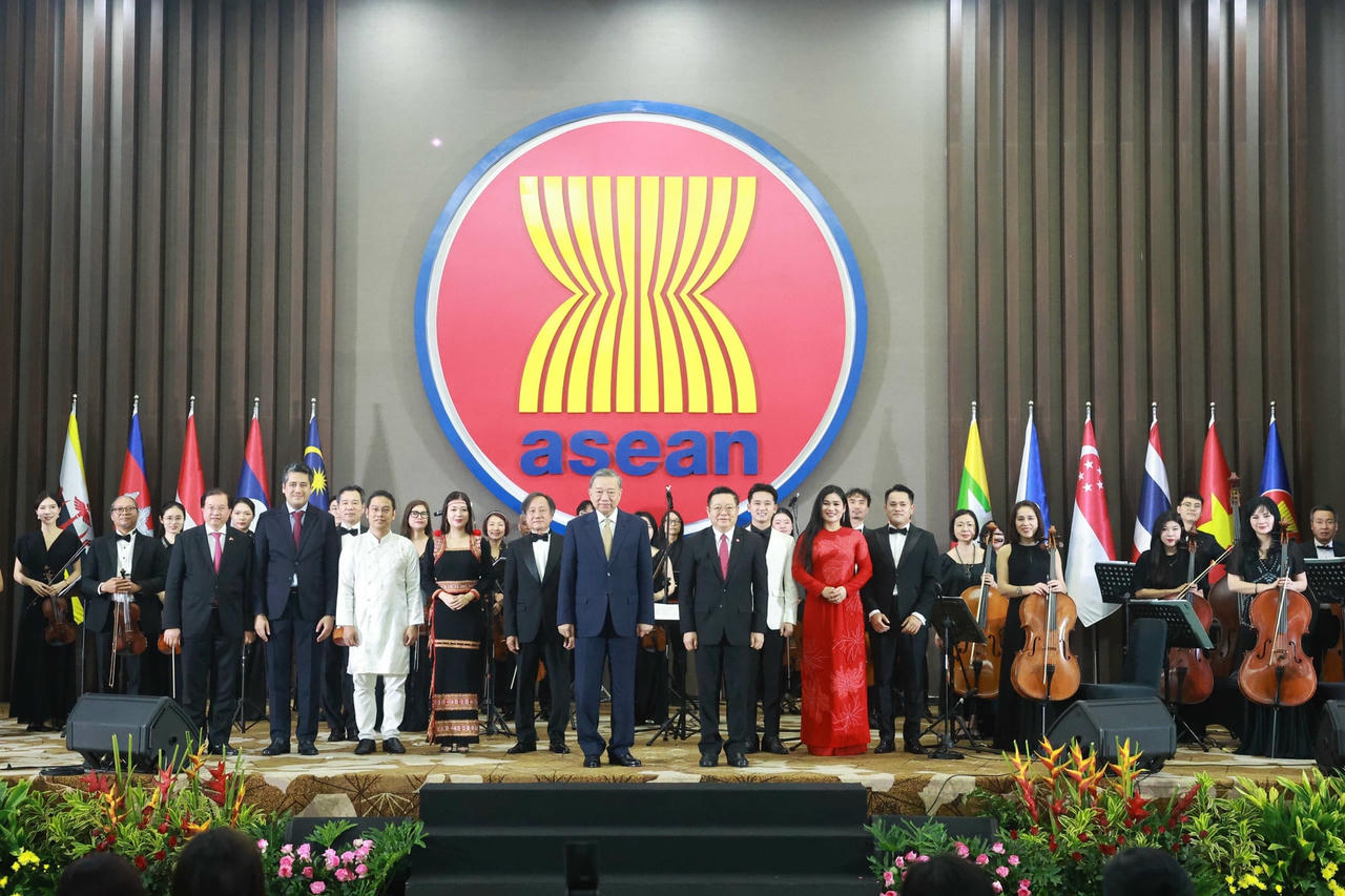 Tổng Bí thư Tô Lâm và Tổng Thư ký ASEAN Kao Kim Hourn chụp ảnh chung với đoàn nghệ thuật trình diễn tại buổi lễ. (Ảnh: Thống Nhất/TTXVN) tong-bi-thu-to-lam-va-phu-nhan-du-le-ky-niem-30-nam-viet-nam-gia-nhap-asean-7904357.jpg