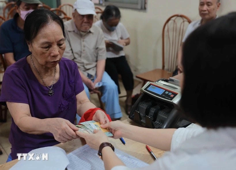Chi trả cho người nhận lương hưu, trợ cấp BHXH tại điểm Nhà văn hóa khu dân cư số 3A-3B Thanh Lương, quận Hai Bà Trưng, Hà Nội. (Ảnh: Hoàng Hiếu/TTXVN) z5573491378541_0c196fe1d083288979a53b1c09f1d635.jpg