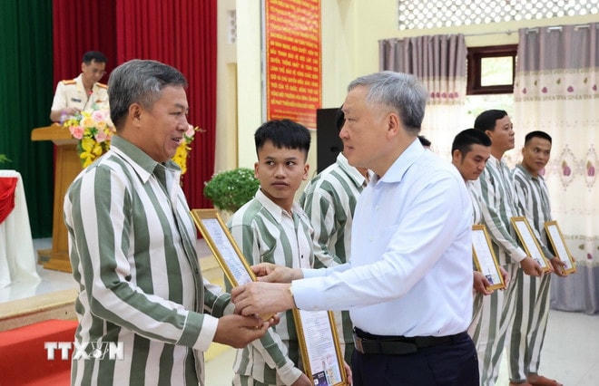 Niềm xúc động của một phạm nhân khi nhận Giấy chứng nhận đặc xá do Phó Thủ trướng Thường trực Nguyễn Hòa Bình trao. (Ảnh: Tiên Minh/TTXVN) ttxvn-cong-bo-quyet-dinh-dac-xa-cua-chu-tich-nuoc-tai-trai-giam-a2-3.jpg