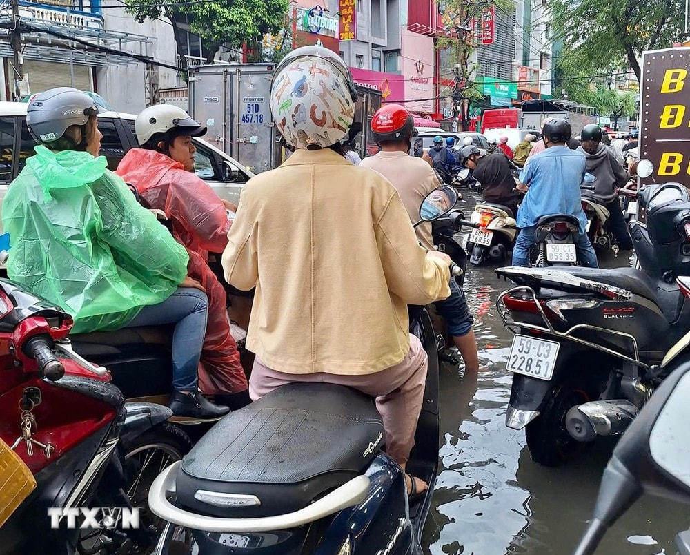 Mưa lớn kéo dài đến giờ tan tầm, gây khó khăn cho các phương tiện lưu thông. (Ảnh; Hồng Giang/TTXVN) ttxvn_mua_tphcm_0810-2.jpg