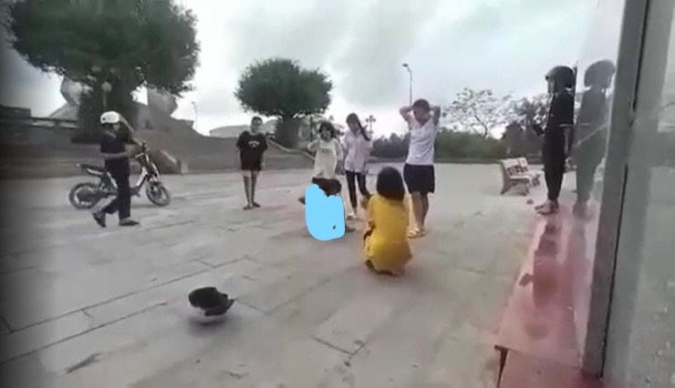 Nữ sinh bị hai bạn nữ khác đánh và lột áo quần. Ảnh cắt từ clip.
