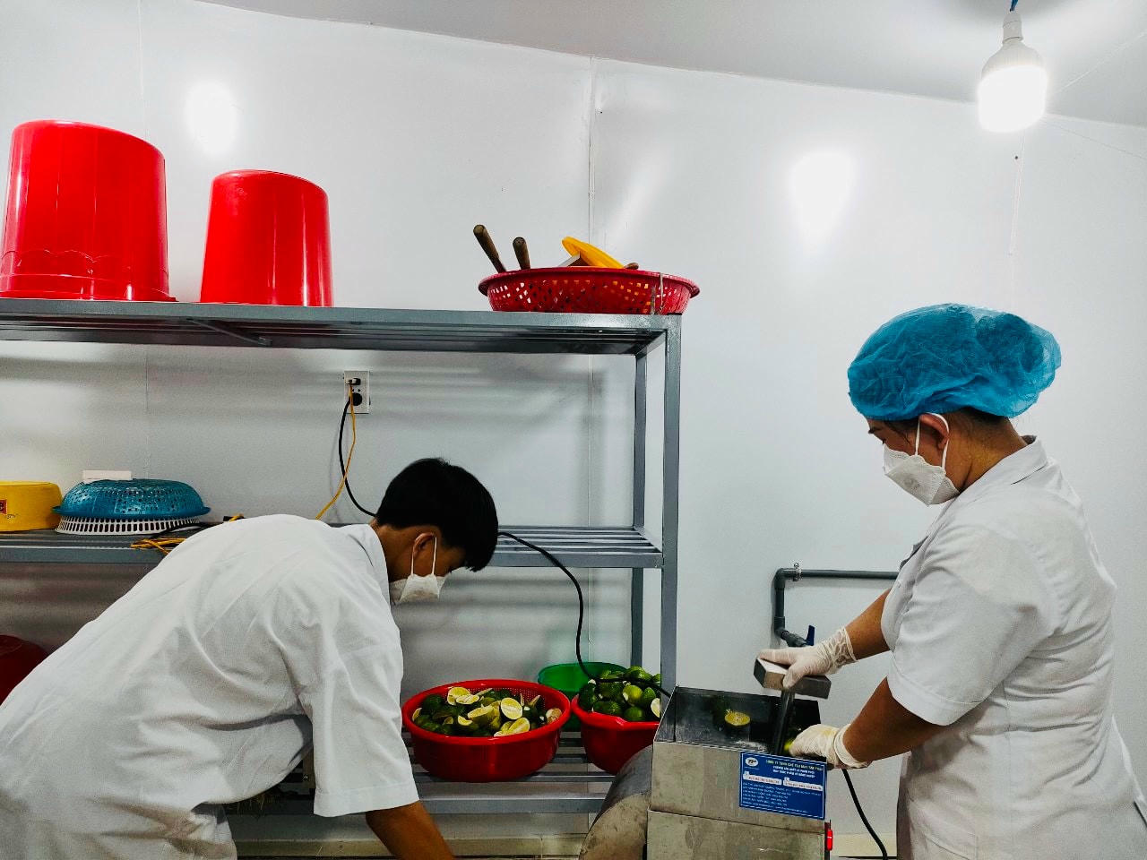 Chị Nguyễn Thị Hồng Vân cùng con trai đang ép nước cốt chanh.