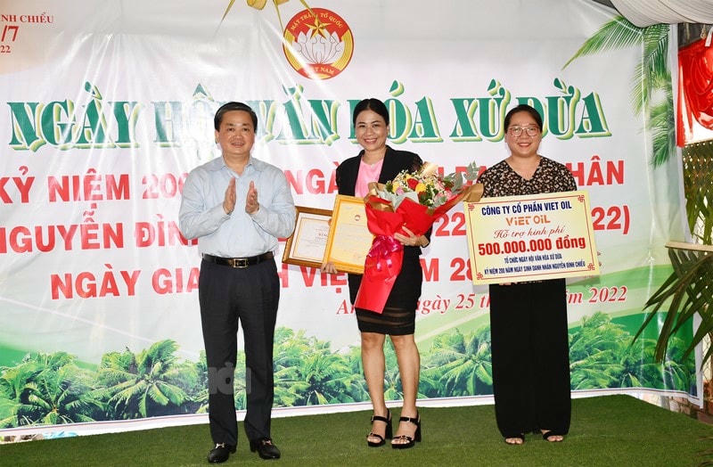 Chủ tịch UBMTTQ tỉnh Nguyễn Thị Hồng Nhung nhận kinh phí từ nhà tài trợ và Bí thư Tỉnh ủy Lê Đức Thọ trao bằng khen và hoa cho nhà tài trợ