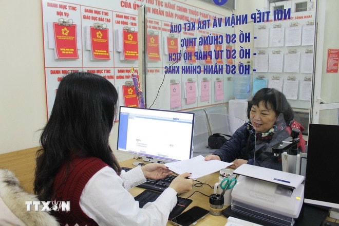 Cán bộ phường hướng dẫn người dân làm thủ tục hành chính. (Ảnh: Nguyễn Thắng/TTXVN) ttxvn-thu-tuc-hanh-chinh-2.jpg