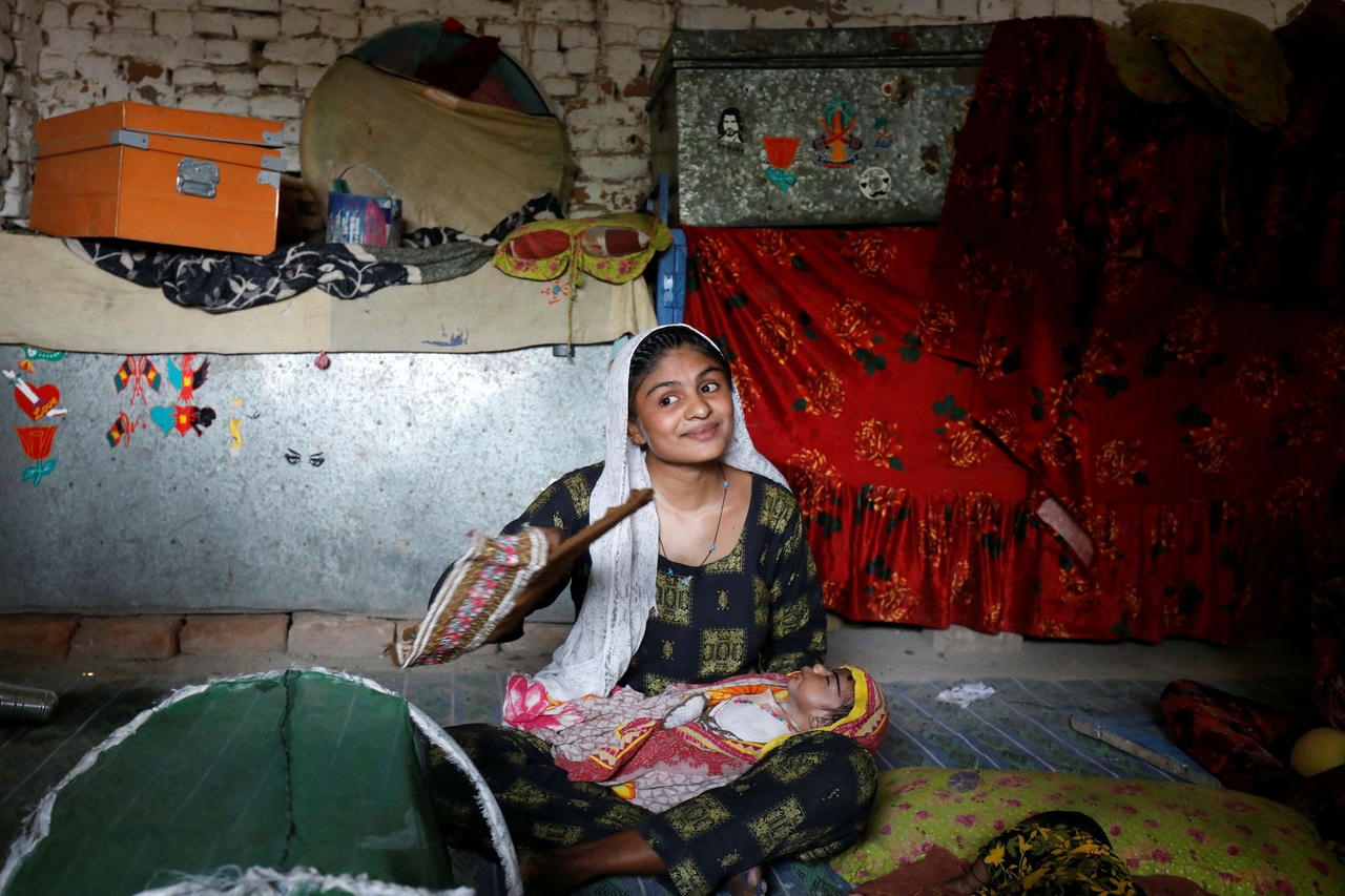 Waderi ôm con ru ngủ giữa cái nóng ở Jacobabad. Ảnh: Reuters.