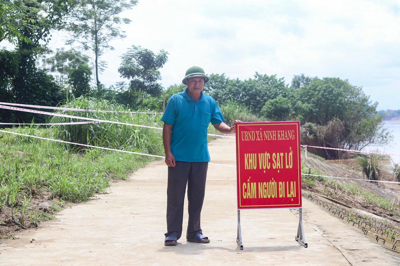 UBND xã Ninh Khang căng dây, đặt biển cảnh báo cấm người qua lại khu vực sạt lở. Ảnh: Đình Minh