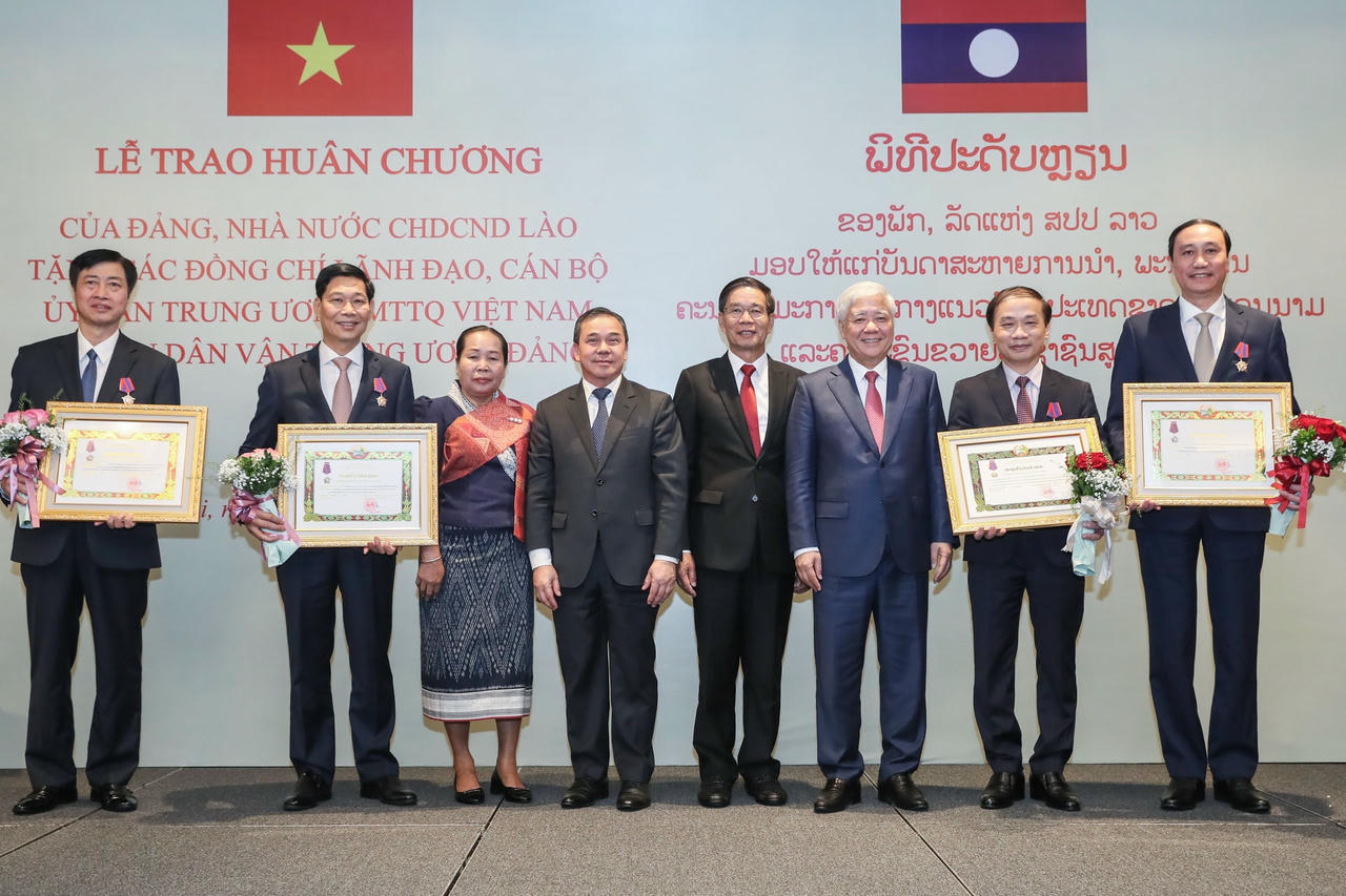 Chủ tịch Uỷ ban Trung ương Mặt trận Lào xây dựng đất nước Sinlavong Khoutphaythoune và Chủ tịch UBTƯ MTTQ Việt Nam Đỗ Văn Chiến chụp ảnh lưu niệm với các đồng chí lãnh đạo, cán bộ UBTƯ MTTQ Việt Nam và Ban Dân vận Trung ương được trao thưởng Huân chương Ít-xa-la.