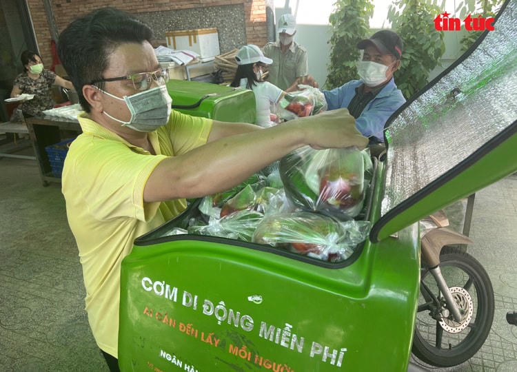 Anh Hải xếp các phần cơm vào trong thùng. Một thùng có thể đựng được 50 phần gồm cơm, thức uống và trái cây kèm theo.