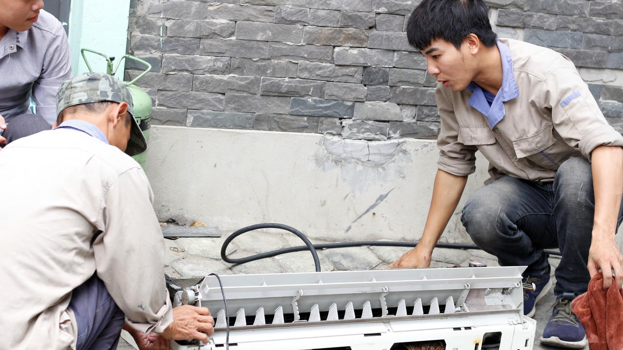 Chú Hùng, 45 tuổi, đồng nghiệp của anh Đức đang vệ sinh vỏ nhựa điều hòa.